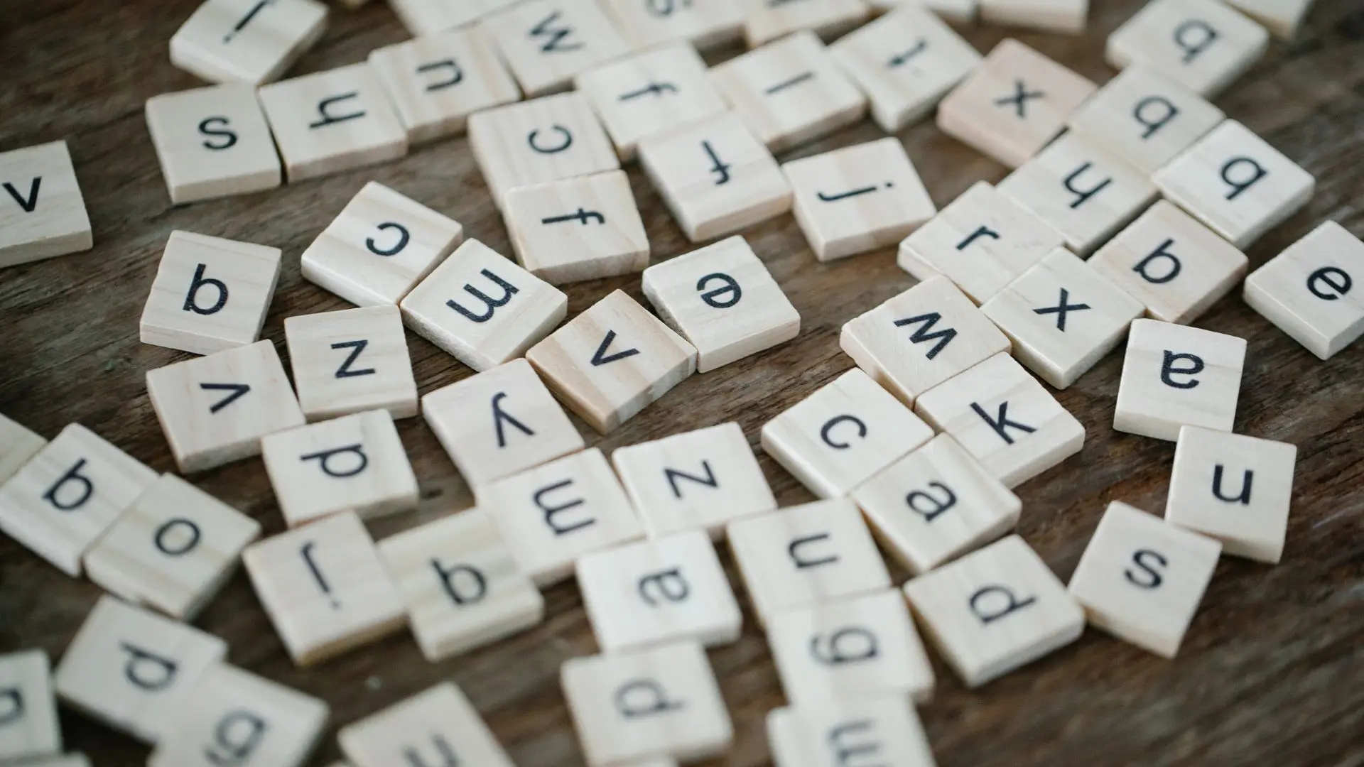 Letras de madera de juego de mesa representando transcripción y traducción de textos