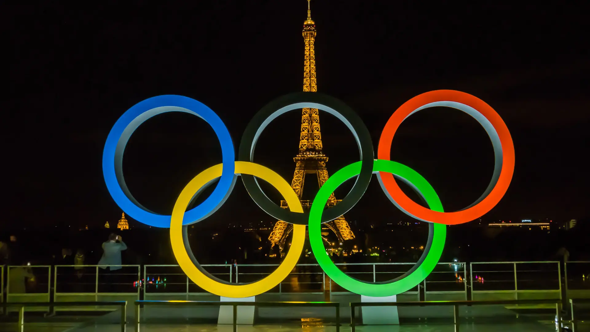 Los aros de los juegos olímpicos frente a la Torre Eiffel