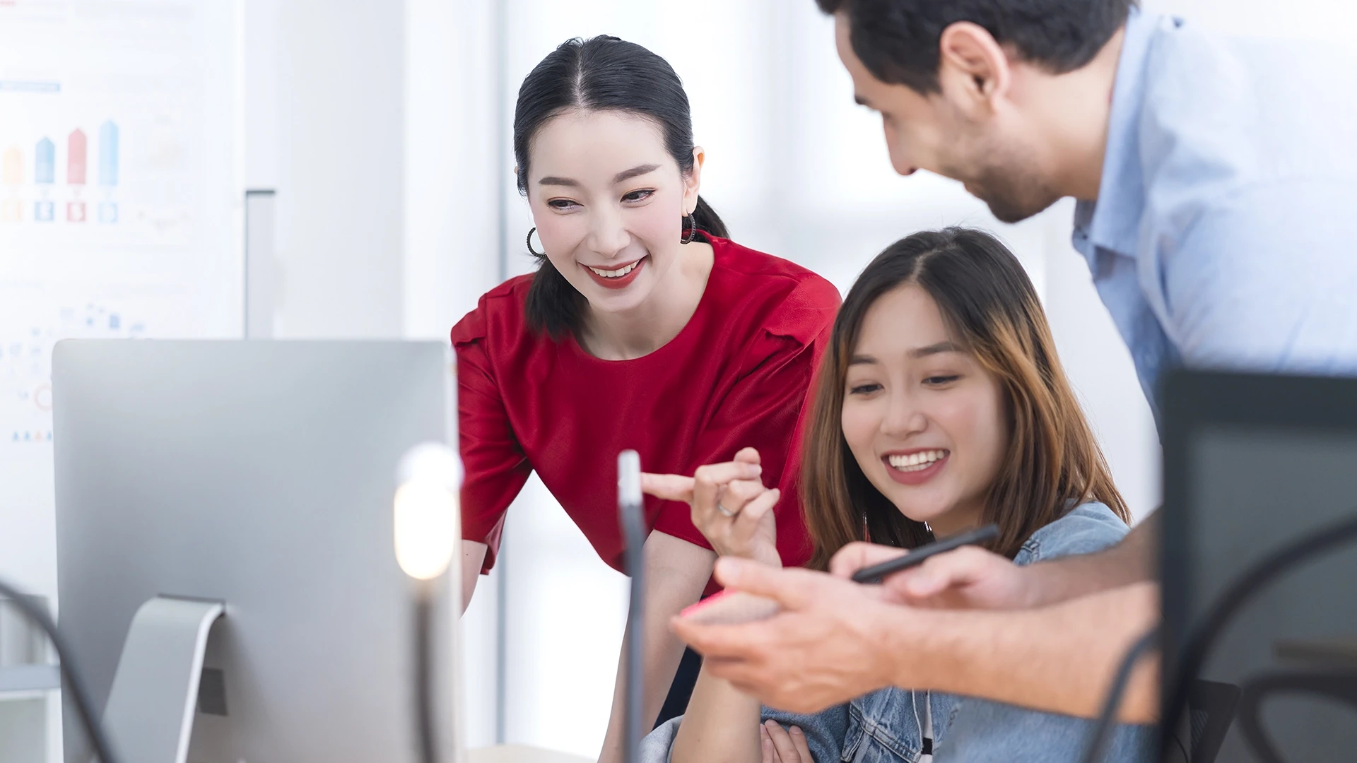 Tres personas en una oficina charlan frente a un ordenador sobre cómo triunfar en marketing digital en China
