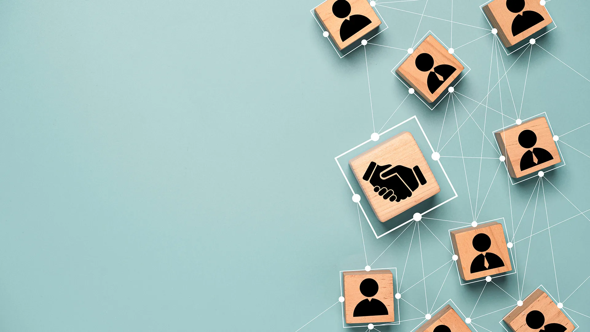 Piezas de madera con monigotes y un símbolo de apretón de manos con lineas conectándolos representando partnerships y colaboraciones