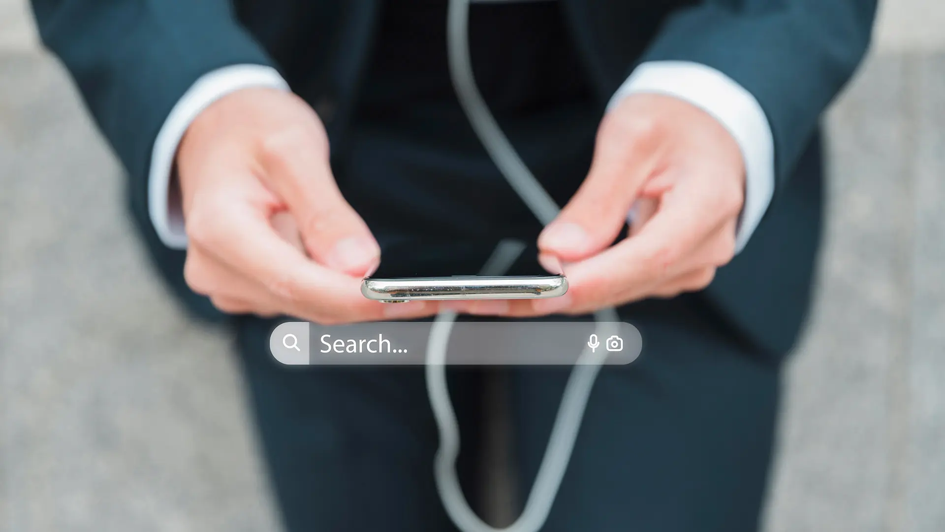 manos de un hombre sujetando un teléfono y haciendo una búsqueda por voz para SEO