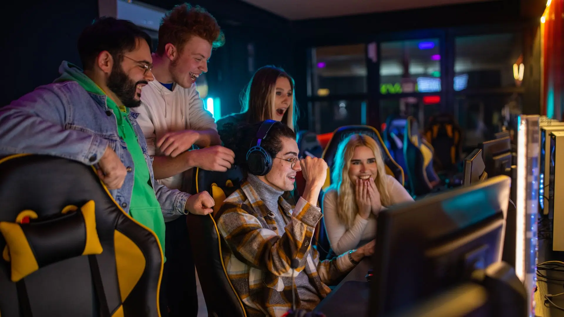 Cinco personas frente a un ordenador celebrando una victoria del mundo de los videojuegos