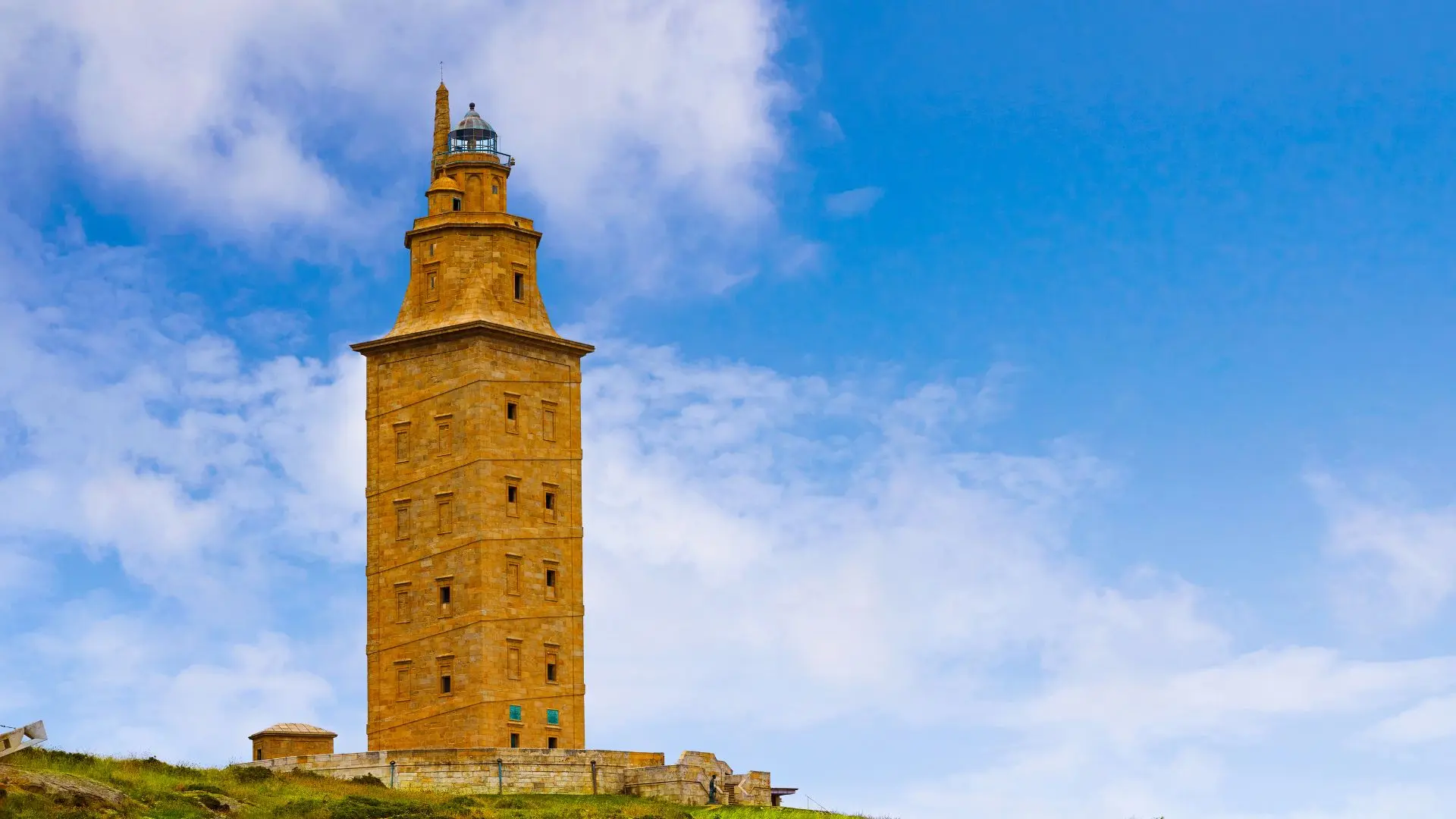Torre de Hércules en A Coruña bajo un cielo azul, símbolo del patrimonio gallego, representando los servicios de un traductor gallego