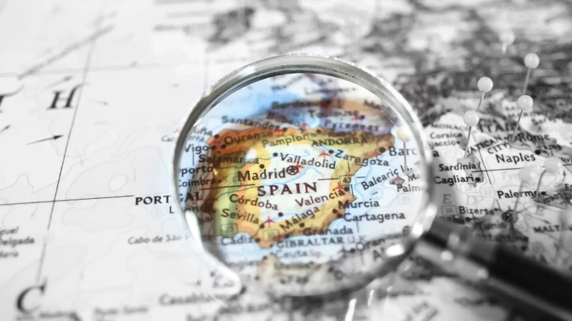 Lupa apoyada en un mapa ampliando el mapa de España representando los idiomas cooficiales de españa