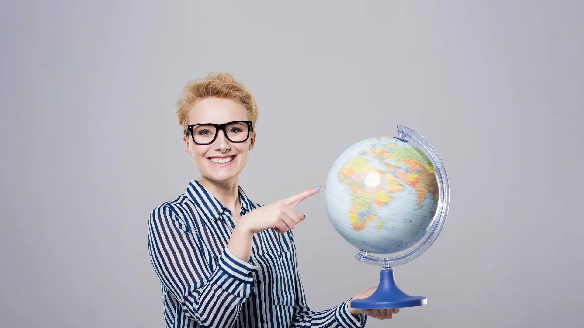 Mujer señalando mapamundi girando sobre los idiomas más hablados del mundo