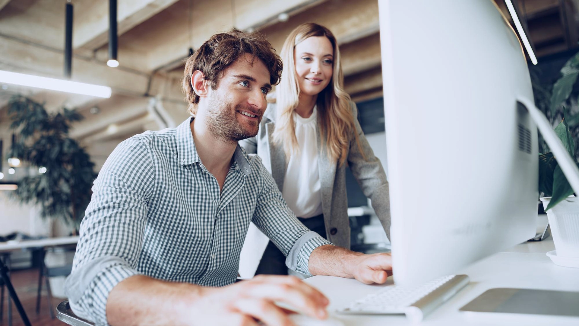 Hombre y mujer miran pantalla de ordenador de Internacionalización web