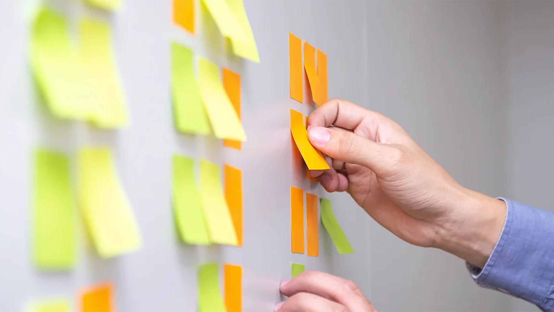 Person sticking notes to a white board to follow the methodology for revising a translation