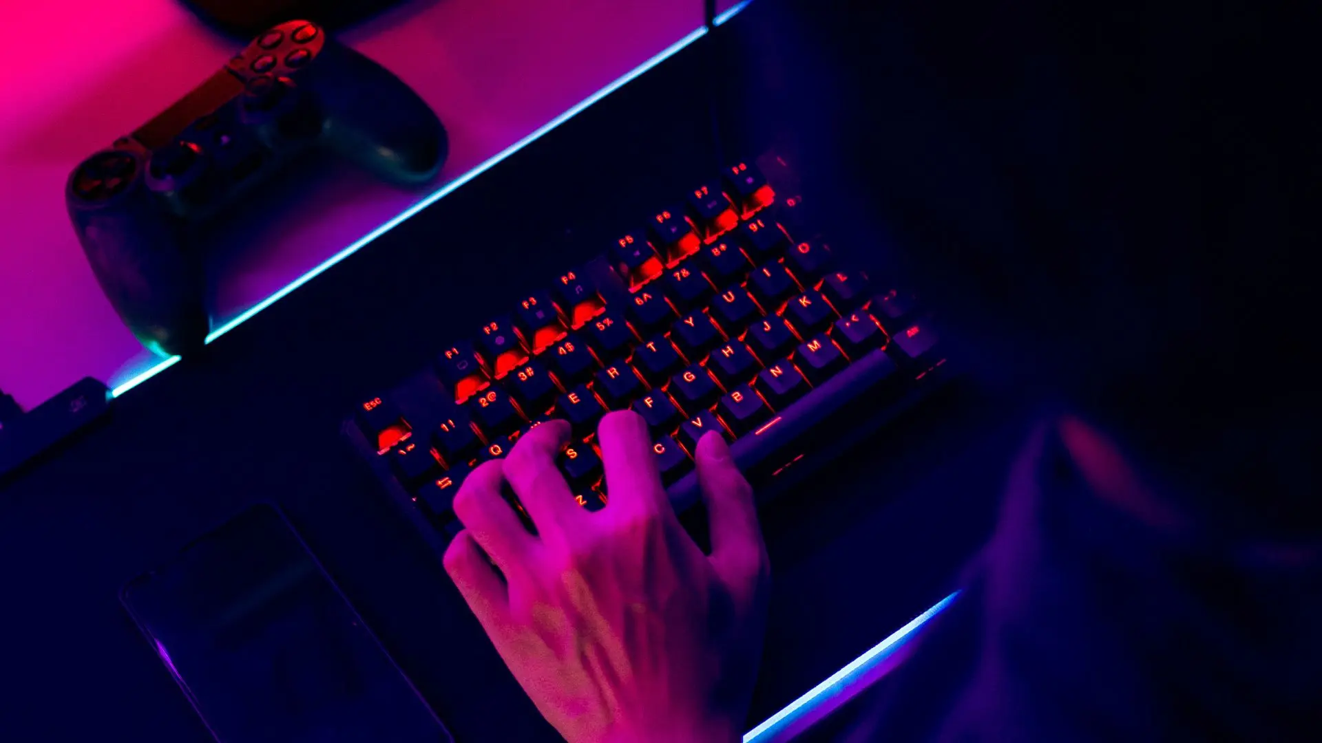 Una mesa con un mando de consola y un teclado sobre el que alguien está escribiendo sobre servicios de traducción de videojuegos