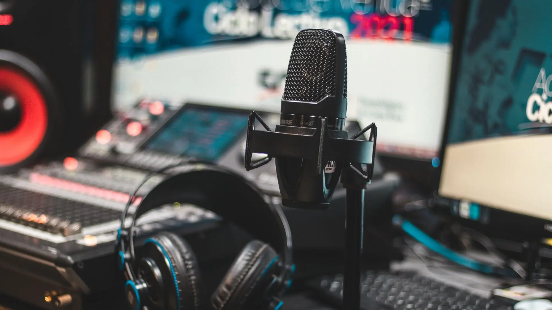 Micrófono y auriculares frente a una mesa de mezclas en un estudio de grabación de traducción audiovisual